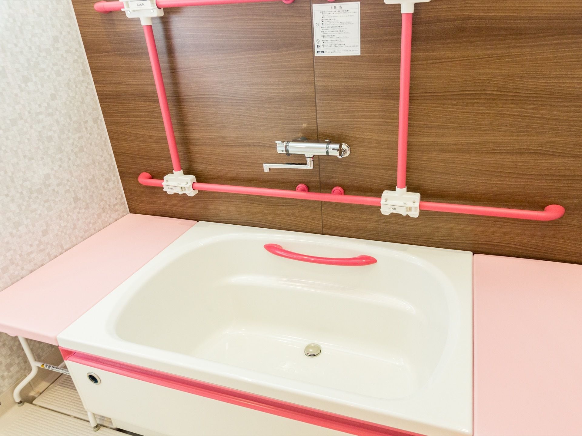 清掃が行き届いた広々とした浴室である。壁には手すりが取り付けられており、バスボードが設置されている。