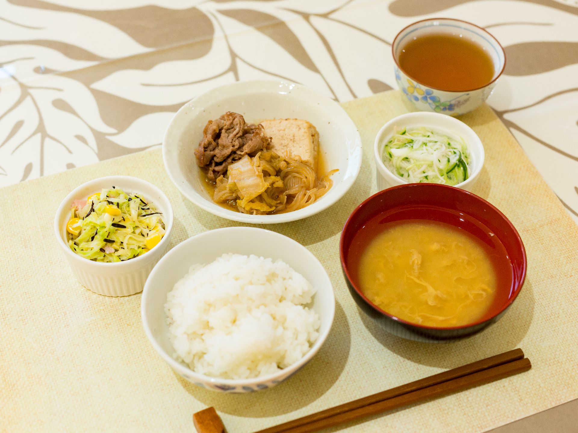 肉豆腐に二種類の小鉢を添えて栄養バランスに配慮された食事