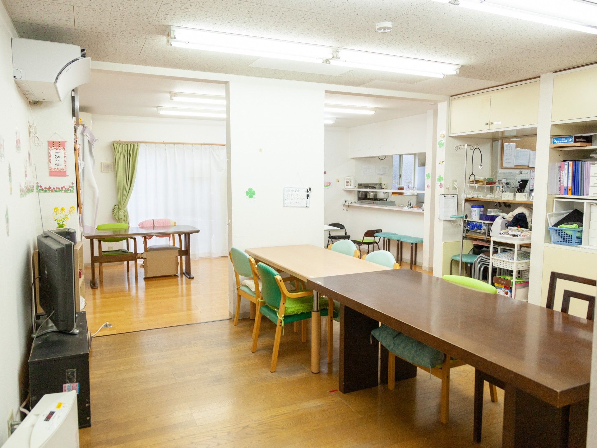 大きな木製のダイニングテーブルが中央に置かれ、奥には対面式キッチンがある。