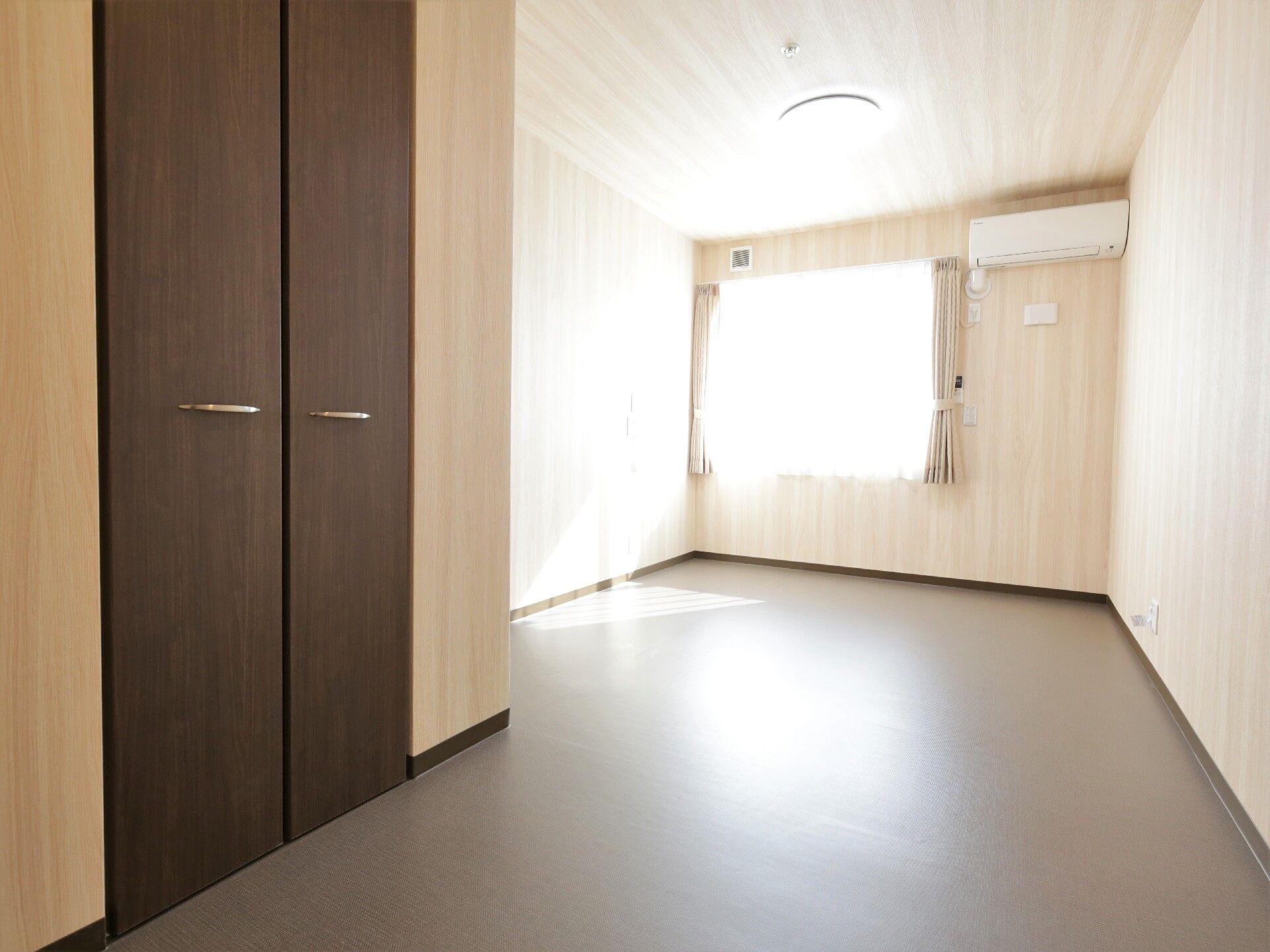 内壁を木目に統一したシンプルでスタイリッシュな部屋