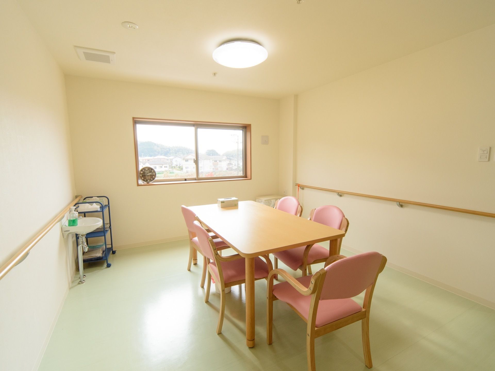 談話室には簡易式の洗面台が備わっている。窓から外の景色を楽しむことができる。部屋の中央にテーブルが置かれている。
