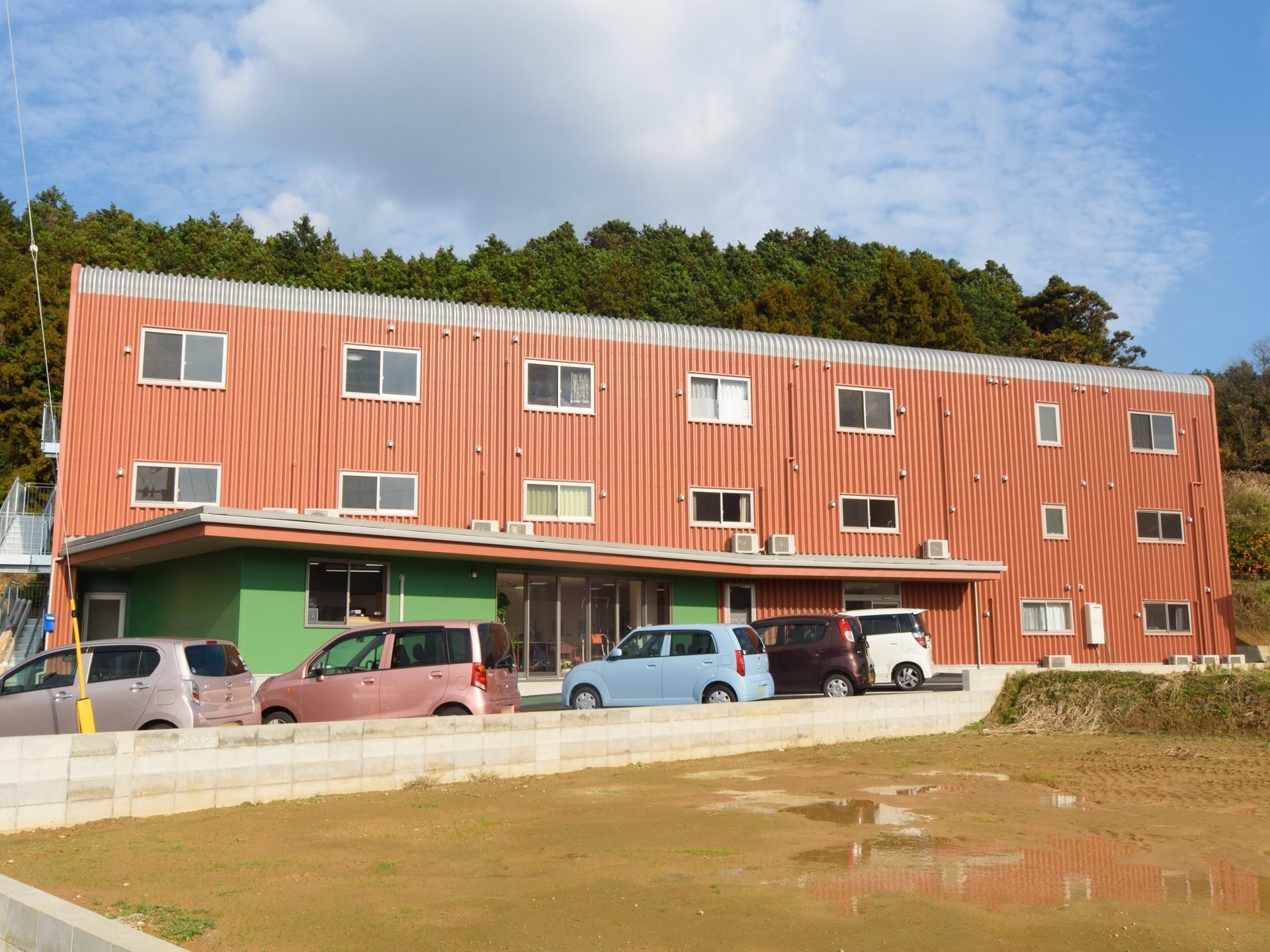 施設は３階建てで、目の前に田んぼが広がっている。裏手には林があり自然豊かな環境である。駐車場が完備されている。