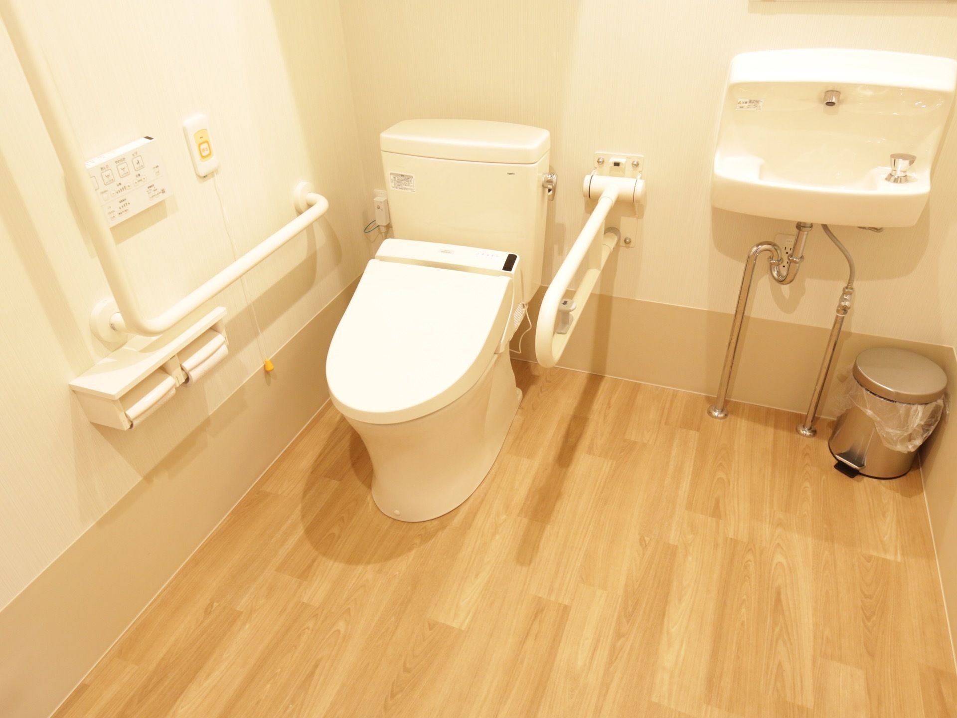 トイレは明るい色合いの内装で、広々とスペースが設けてある。洗面台も併設されていて、機能的なデザイン。