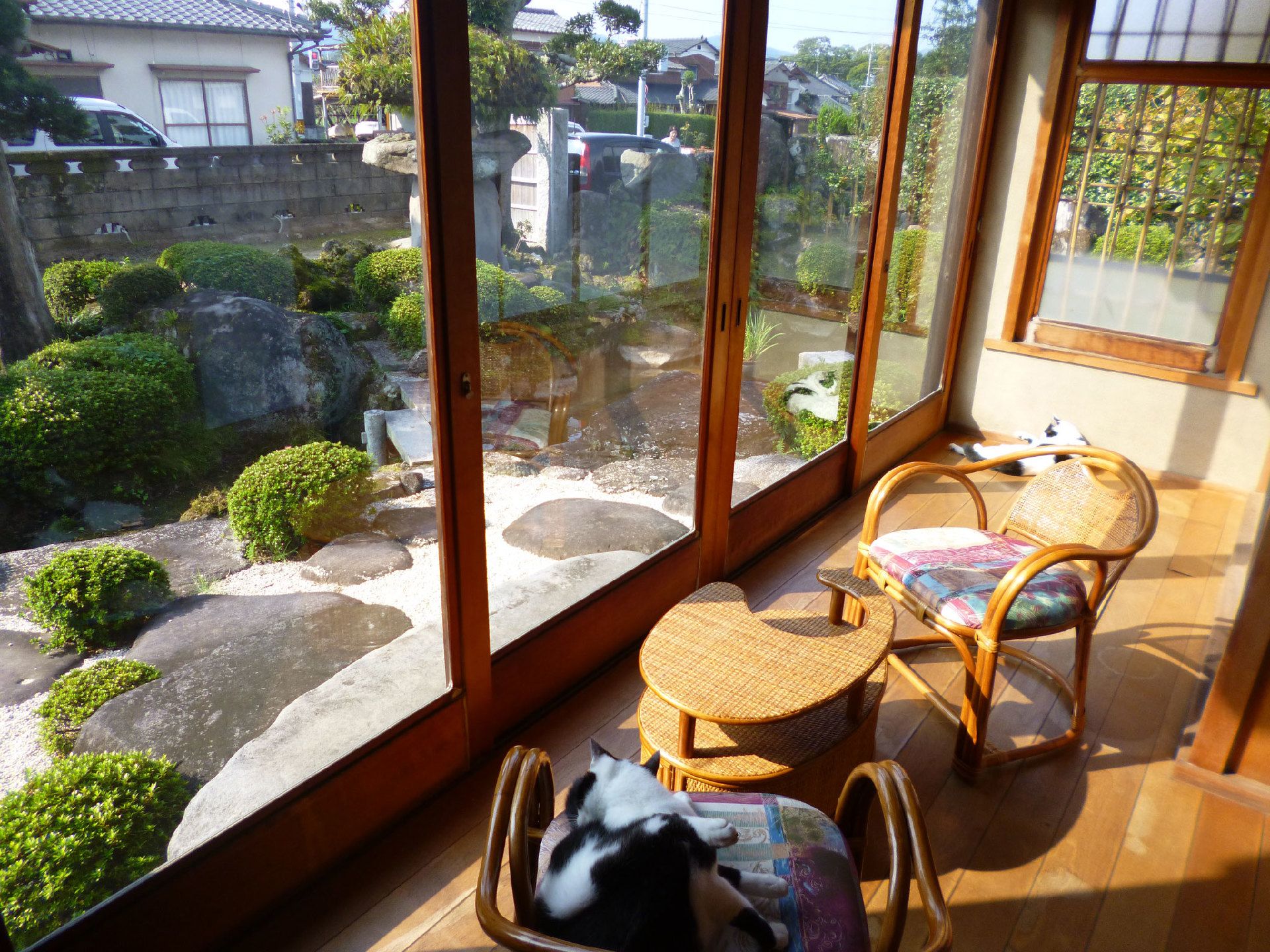 和風庭園を眺めながら日向ぼっこができる館内。テーブルセットが置かれている。