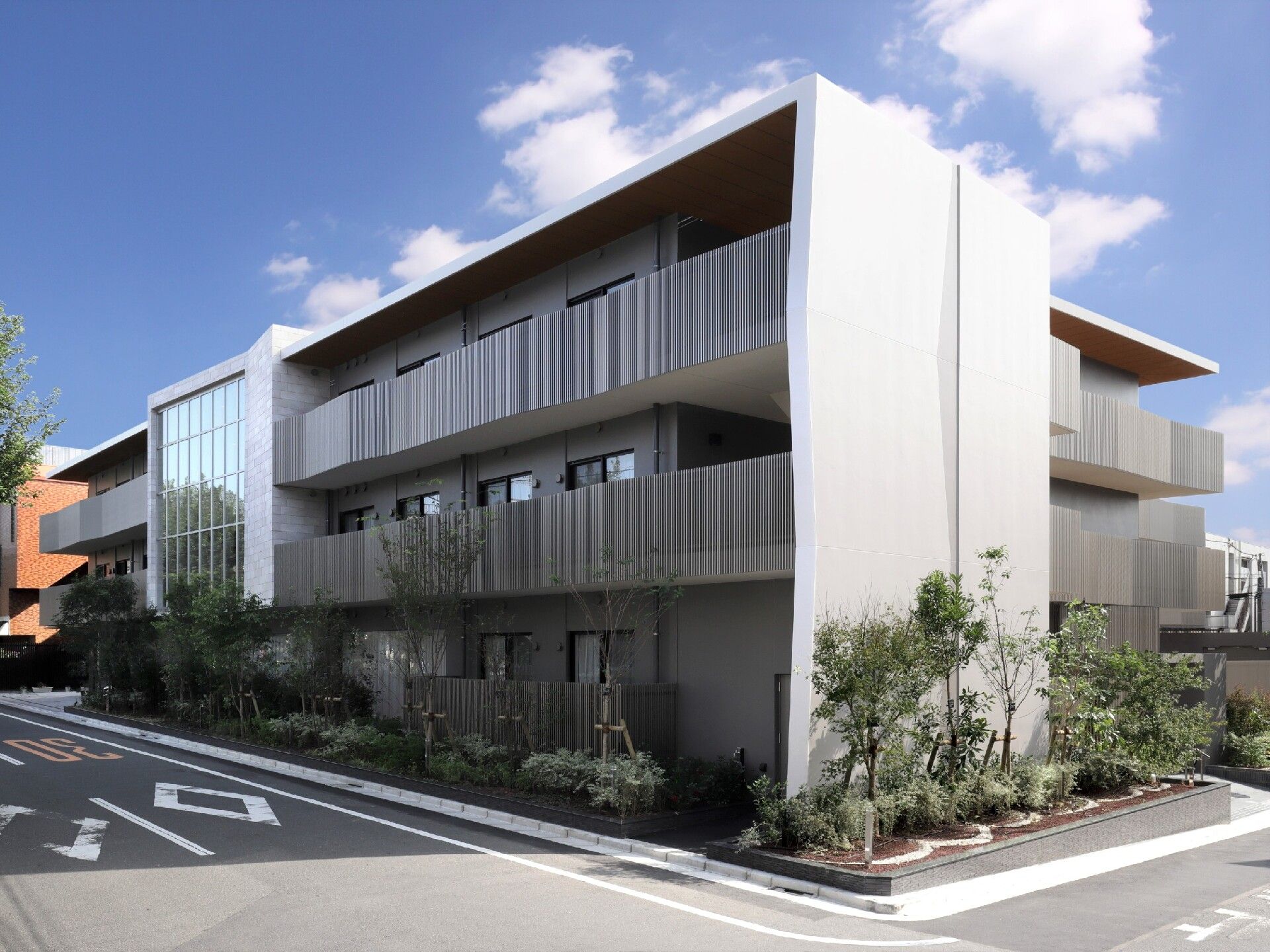 各フロアにベランダがあり、建物周辺には草木が植えられた住宅。3階建てでスタイリッシュなデザイン。