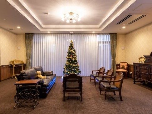 クリスマスツリーが飾られた共有スペースには革張りのソファやアンティーク調の椅子や家具が並んでいる。
