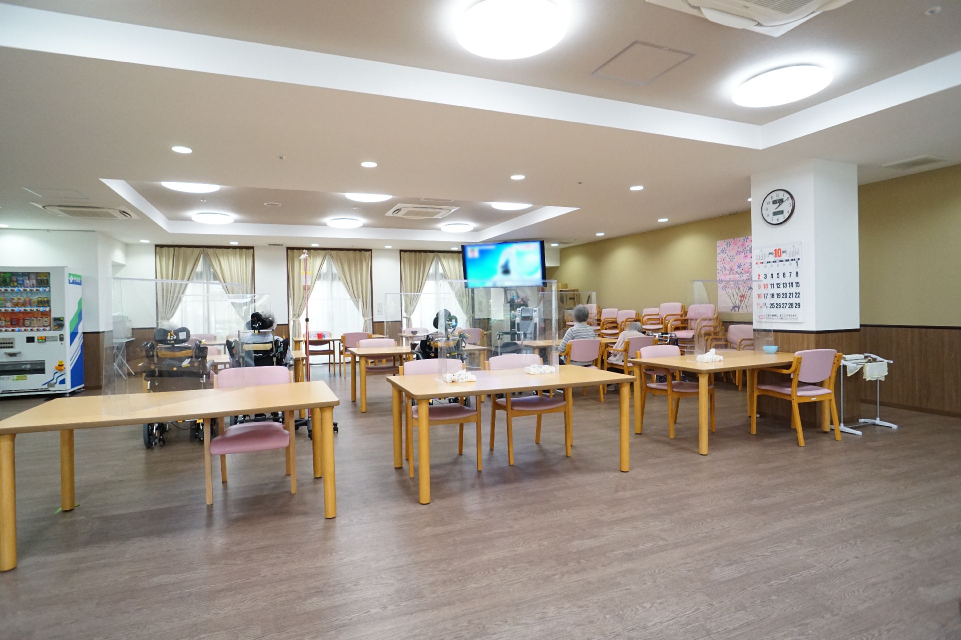 椅子と仕切り板がついているテーブルが設置された共有スペース