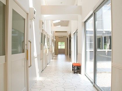 廊下には手すりが付き、まっすぐで奥にはドアが付いている。白を基調とした造り。
