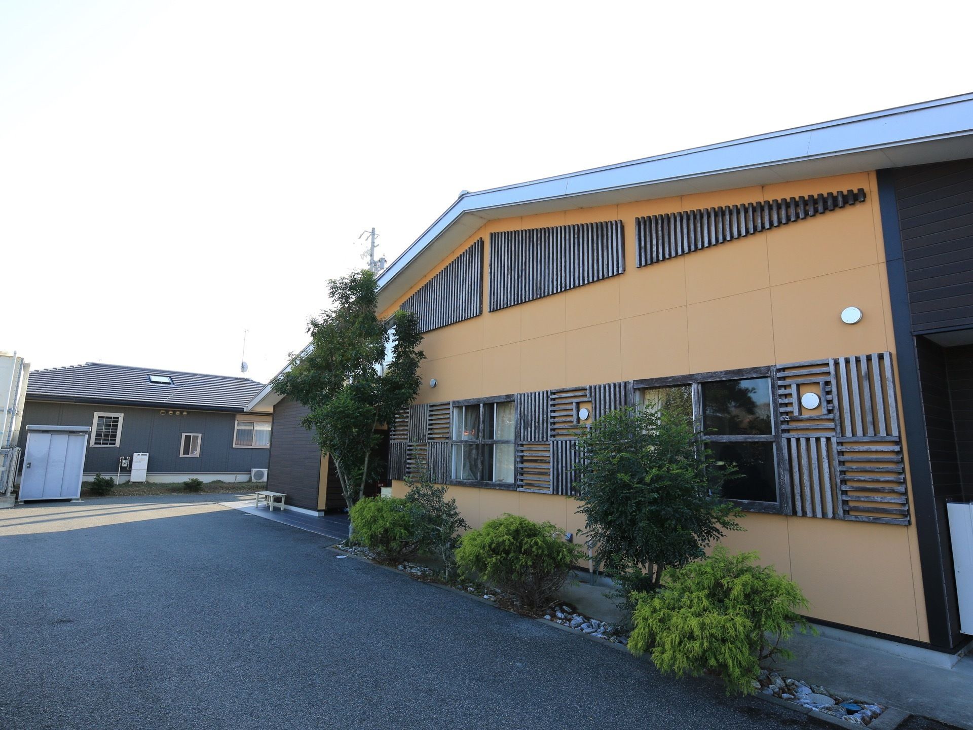 純和風で個性のある平屋建てである。周辺はアスファルトで整地されており、手入れの行き届いた植え込みがある。