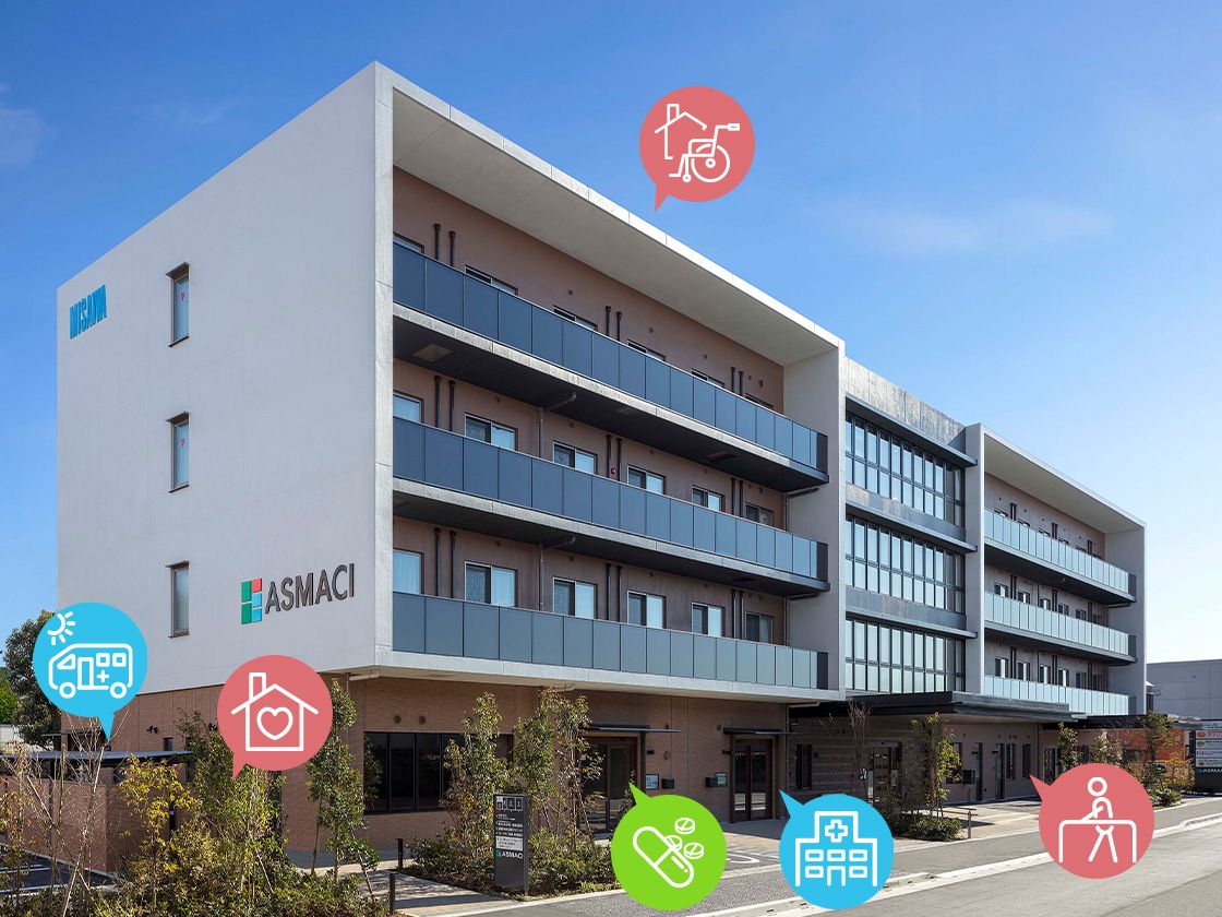 施設外観。バルコニー付きの大きな建物で光がとりこめるような設計