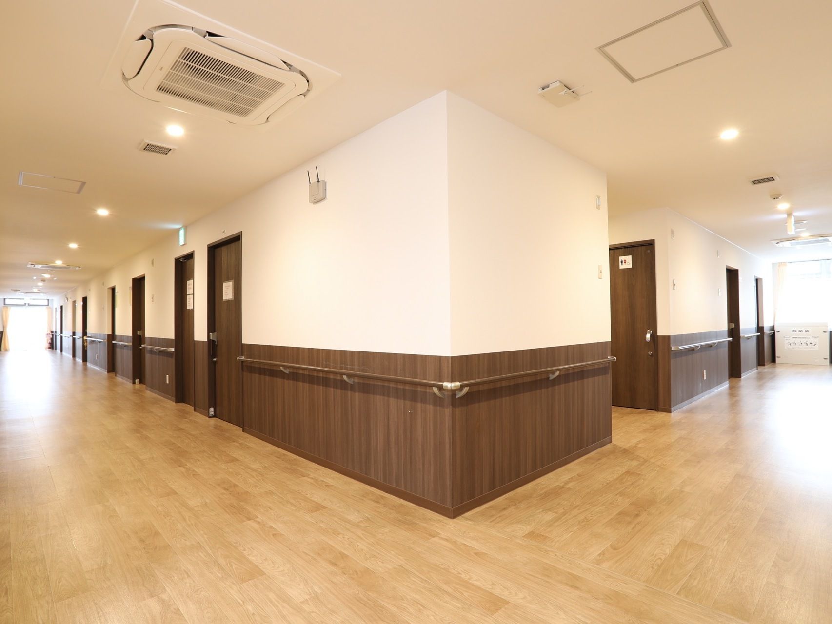 開放的な広さに設計された通路である。壁には茶色の腰板が貼られ、高級感がただよう。手すりもがある。
