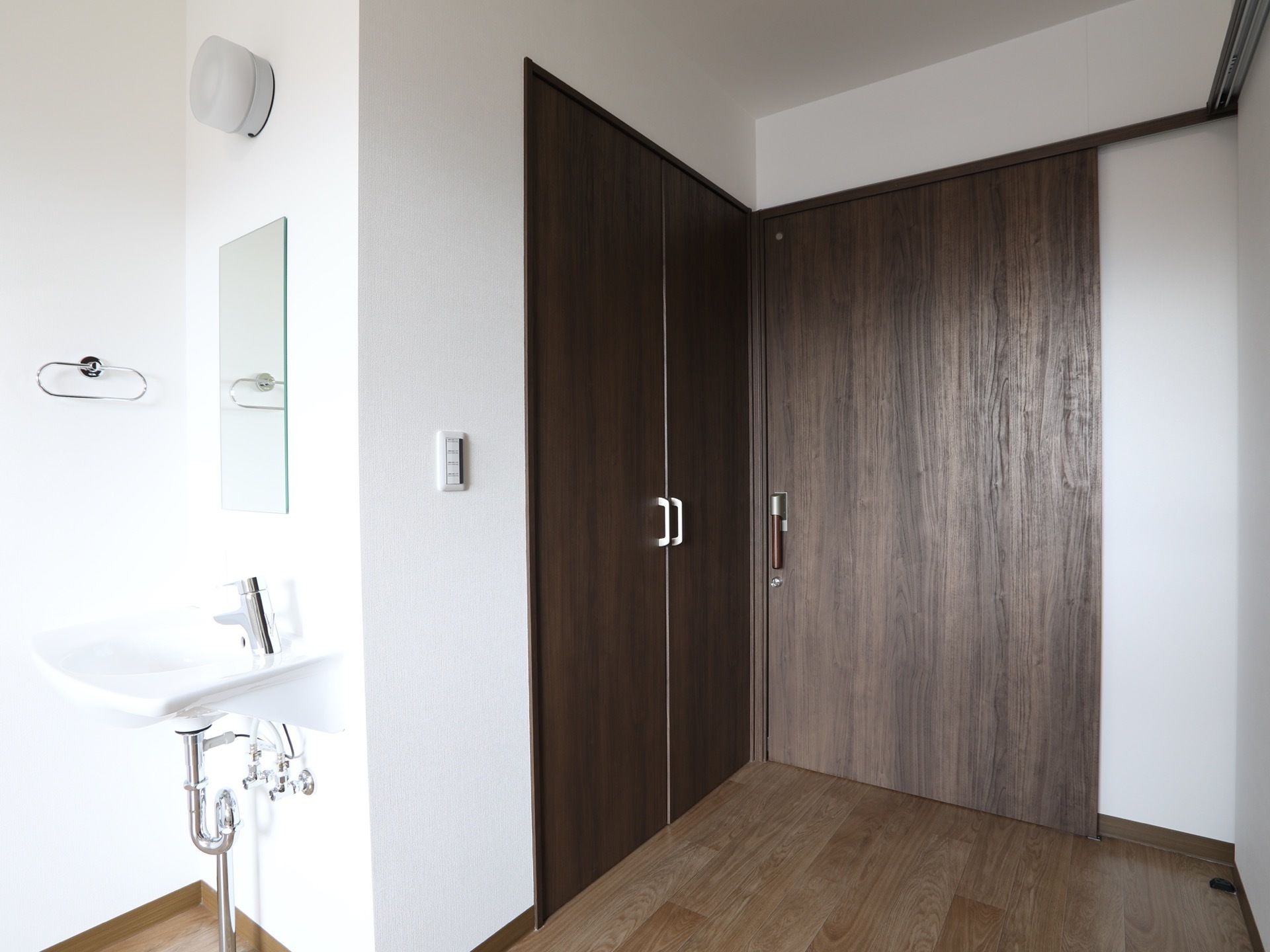 建具は同系色に統一され、シックなデザインに仕上がっている。両開き仕様のクローゼットもある。近くにスイッチがある。