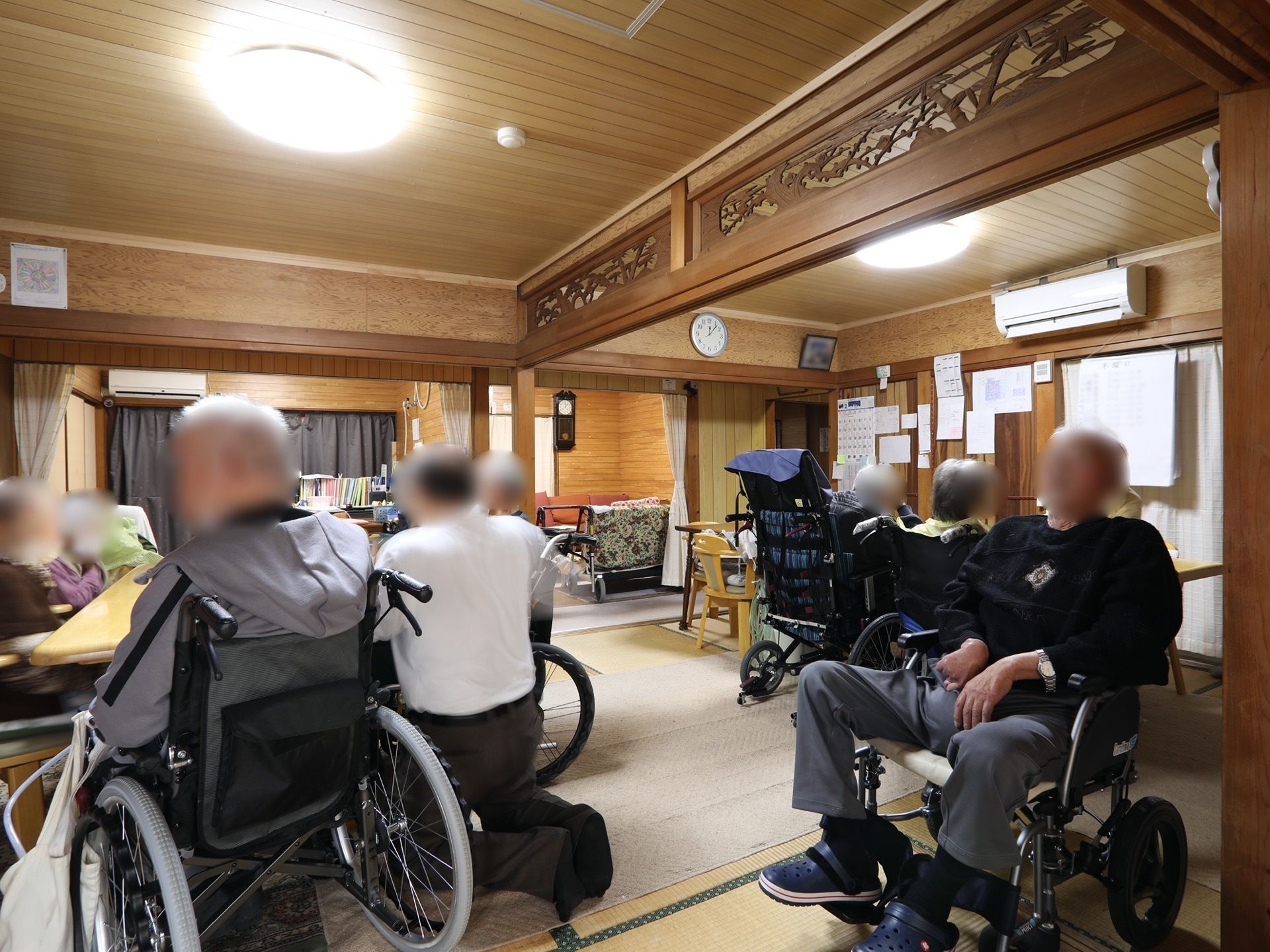 畳が敷かれた、共有スペースがある。天井には複数の丸型照明を完備。入居者様が集まって、くつろいでいる。
