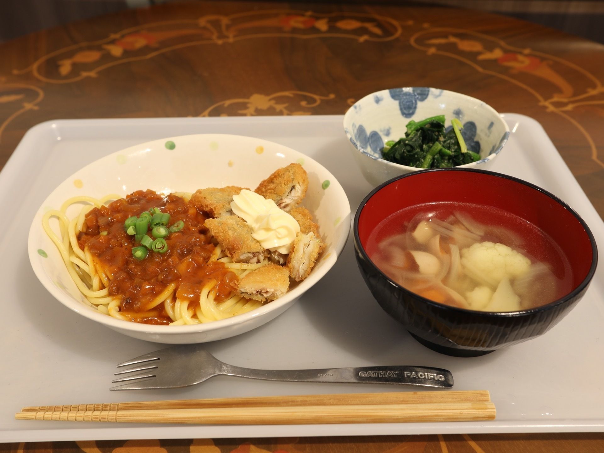 茶色のテーブル上に料理が置かれている。ミートソーススパゲティをメインとした、洋風メニューがならんでいる。