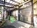 日本家屋風の建物の玄関がある。茶色い格子の引き戸の玄関扉があり、上にはアクリルの屋根が付いている。奥にも扉があり、スロープが続いている。