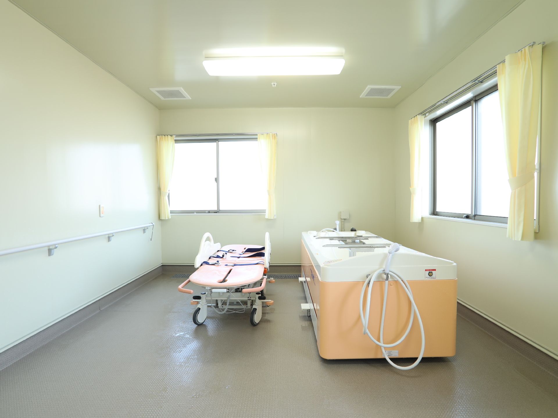 手すりが設置されており、介護用入浴設備が備えられた浴室