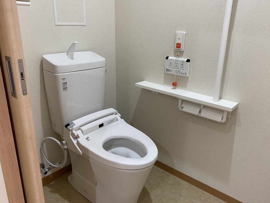 スライド式のドアが設置されたトイレには呼び出しボタンや手すりが付き、ドアはスライド式。