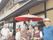 赤い傘の下で記念撮影をする入居者とスタッフ。外出イベントの様子。