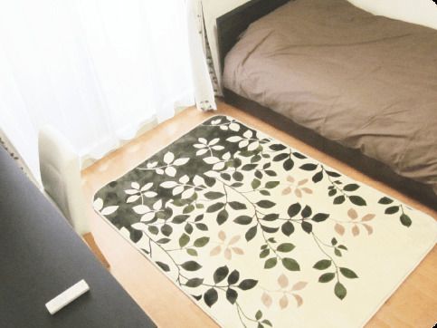 大きな窓があり明るい雰囲気。居室には、ベッドや収納家具だけでなくカーペットもある。