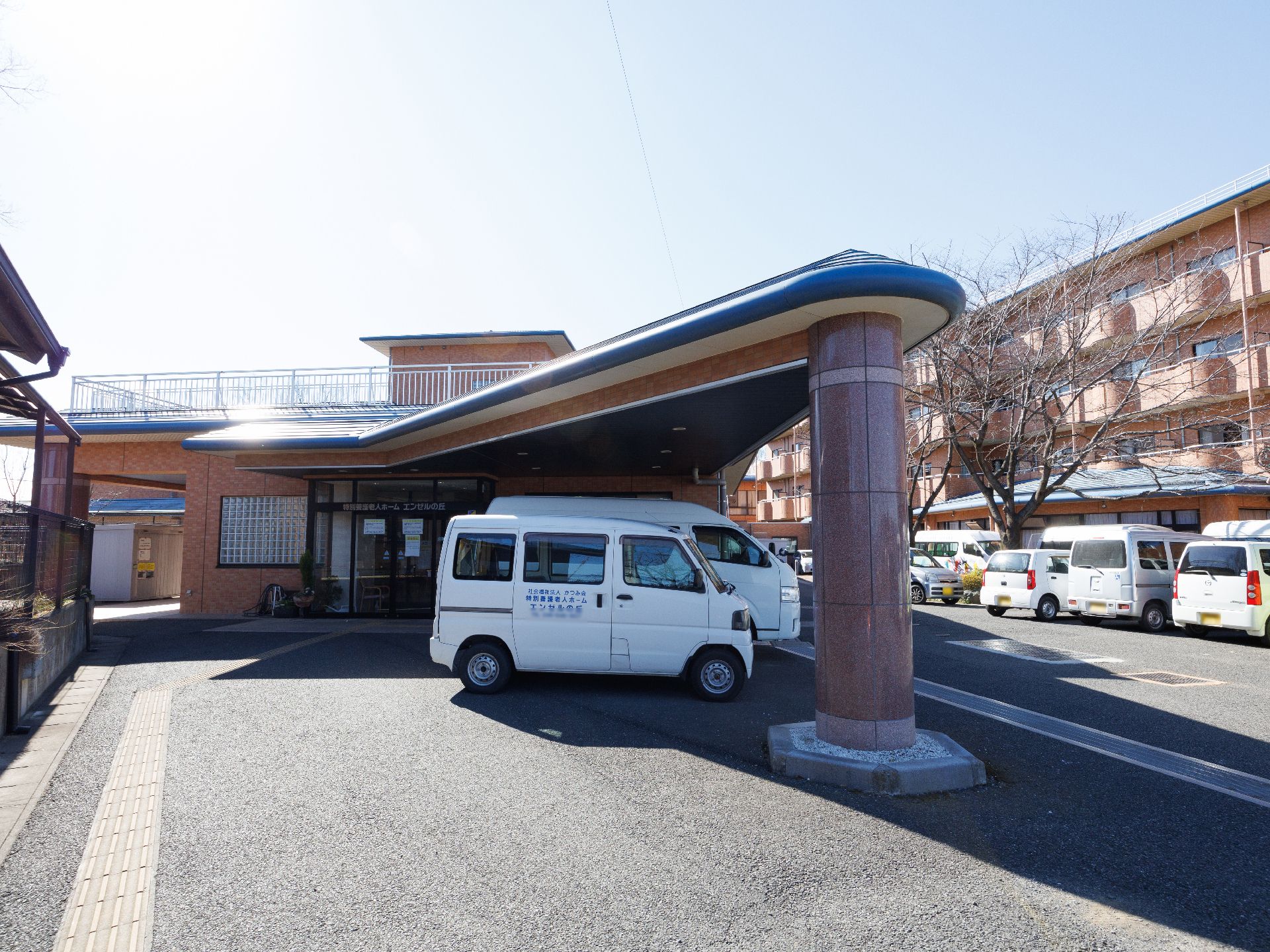 車椅子に乗った笑顔の高齢女性と介助をする女性ヘルパー