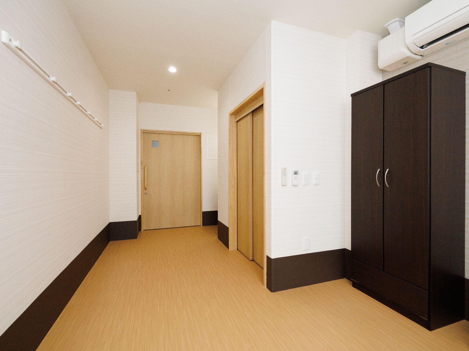 白い壁の部屋に置かれた黒の収納