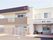 ２階建ての建物。ベージュを基調とし、２階にはベランダが付き、外壁にはホーム名が書かれている。
