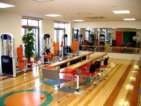 健康訓練機器が複数設置され、一壁面が鏡張りの機能訓練室