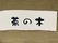木材でできた看板に習字でホーム名が書かれている。ショートステイという文字が消されている。