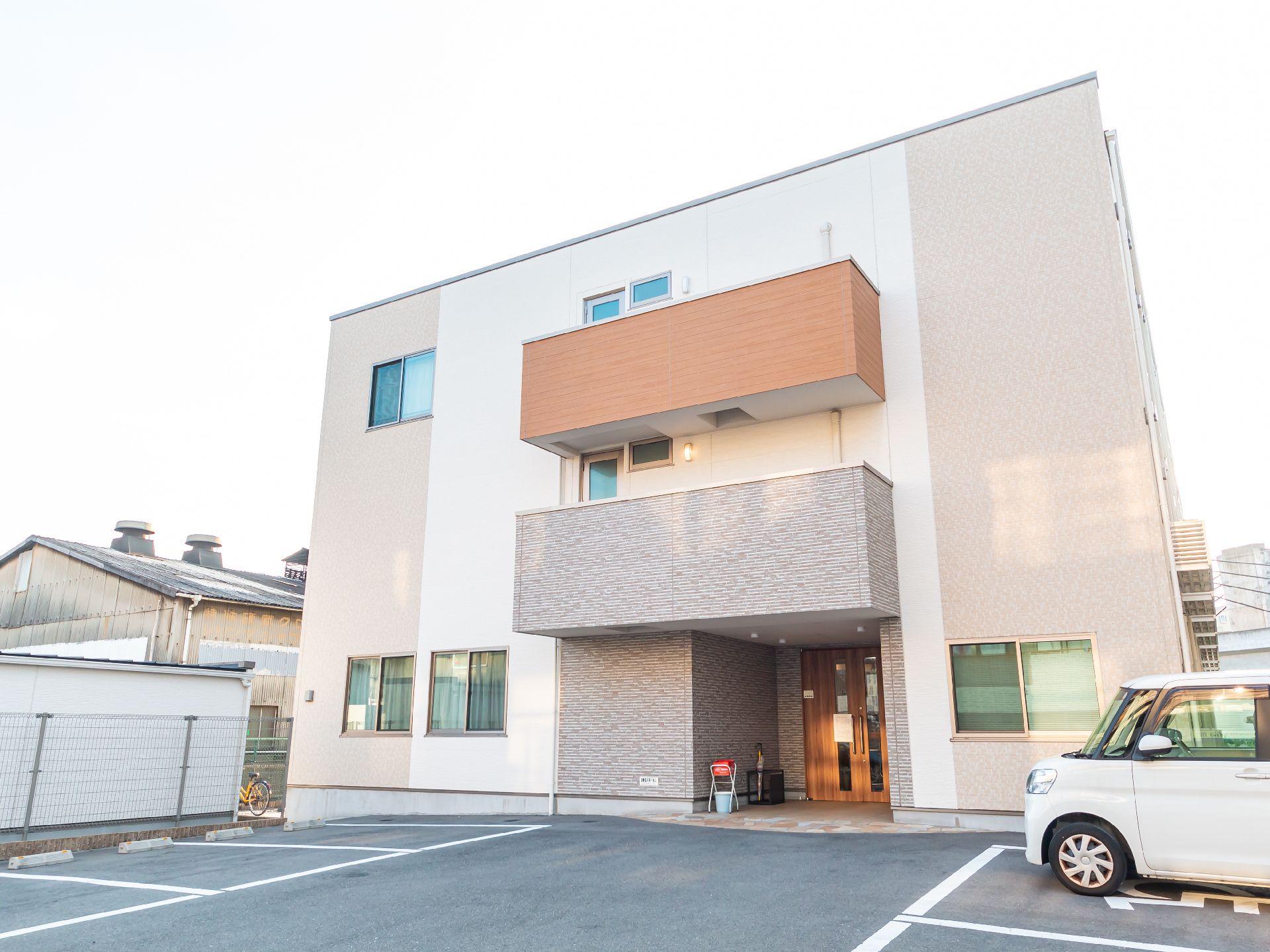 広い駐車場が隣接している、おしゃれな屋根のある介護施設