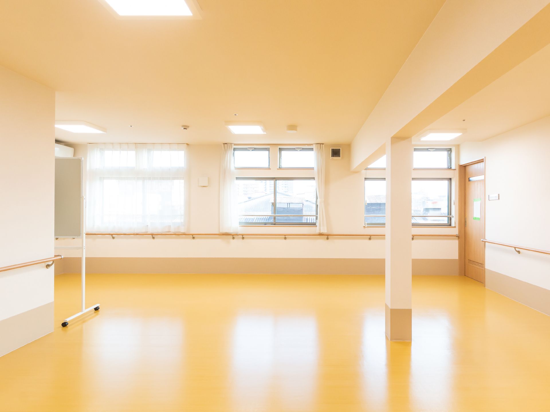 カメラに向かって笑顔を見せるスタッフと高齢者の女性。施設での何気ない一場面の様子