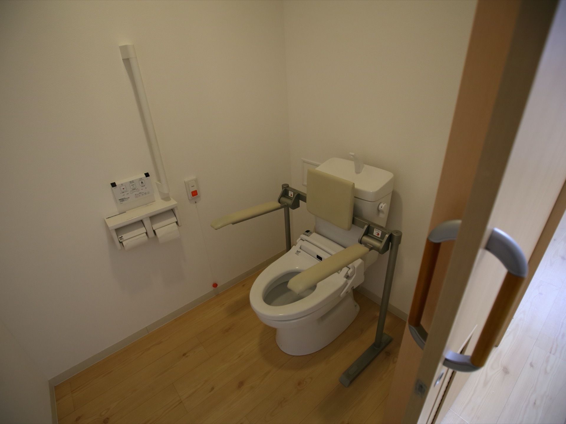 トイレは個室で床はフローリング仕様である。洋式の温水洗浄機能付きの便座で、手すりもあり安心してご利用いただける。
