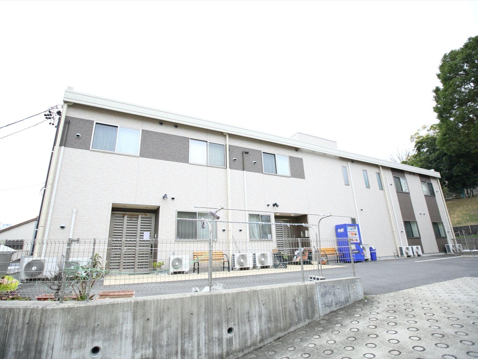 建物は2階建てで高さもあまりない。周辺は静かな環境であり、施設の前も勾配の小さな坂が展開されている。