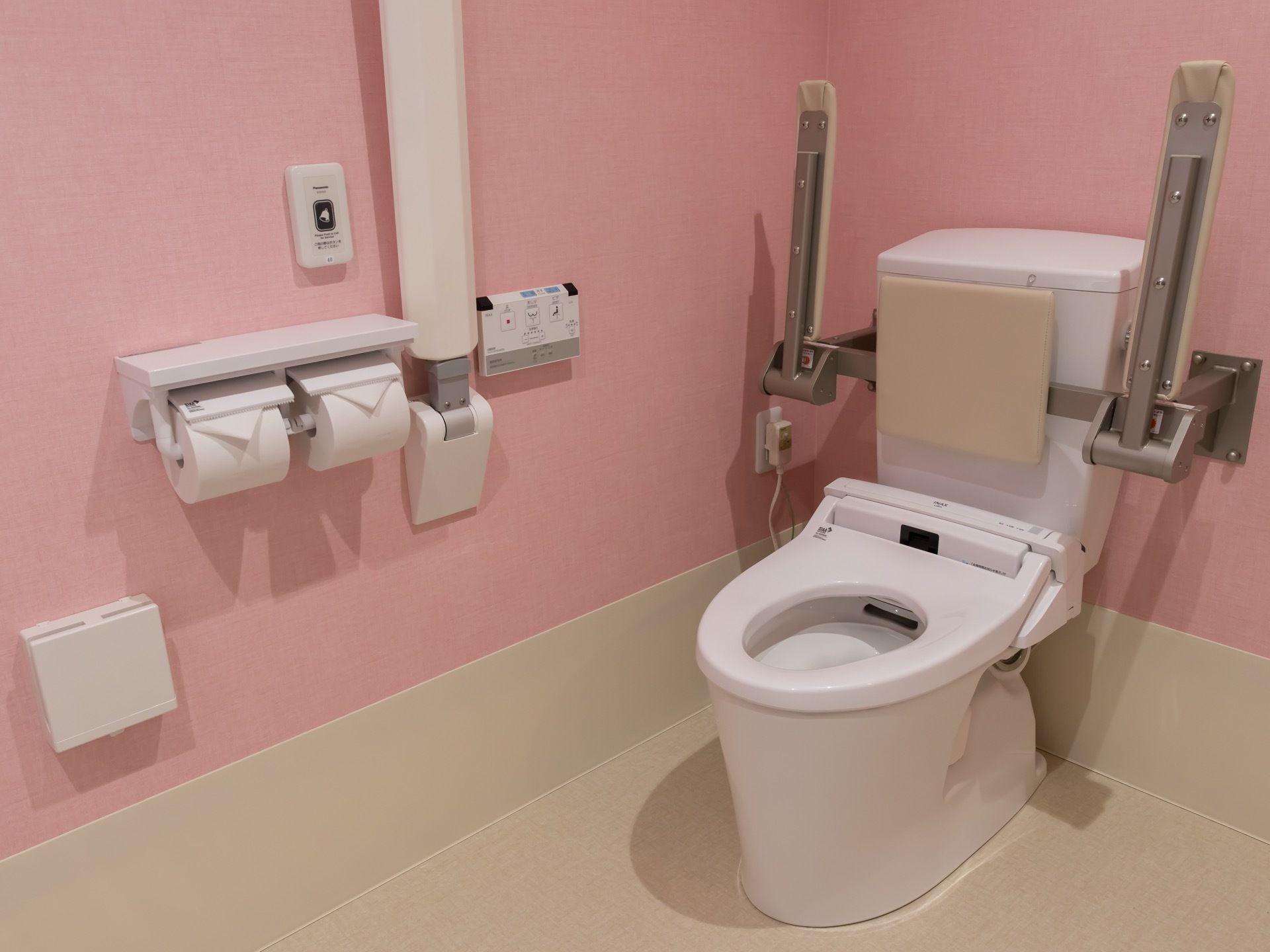 手すりや背もたれ、はねあげ式の前方ボードが備わったトイレである。緊急時呼び出しボタンが設置されている。