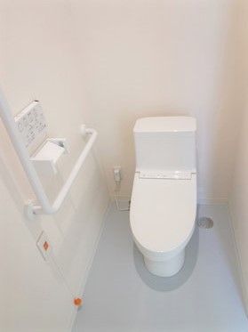 呼び出しボタンや手すりが付いたシンプルなトイレは白を基調としている。