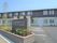 花壇にはホームの看板も立っていて、2階建ての建物は1階部分が白、2階部分がダークグレーになっている。