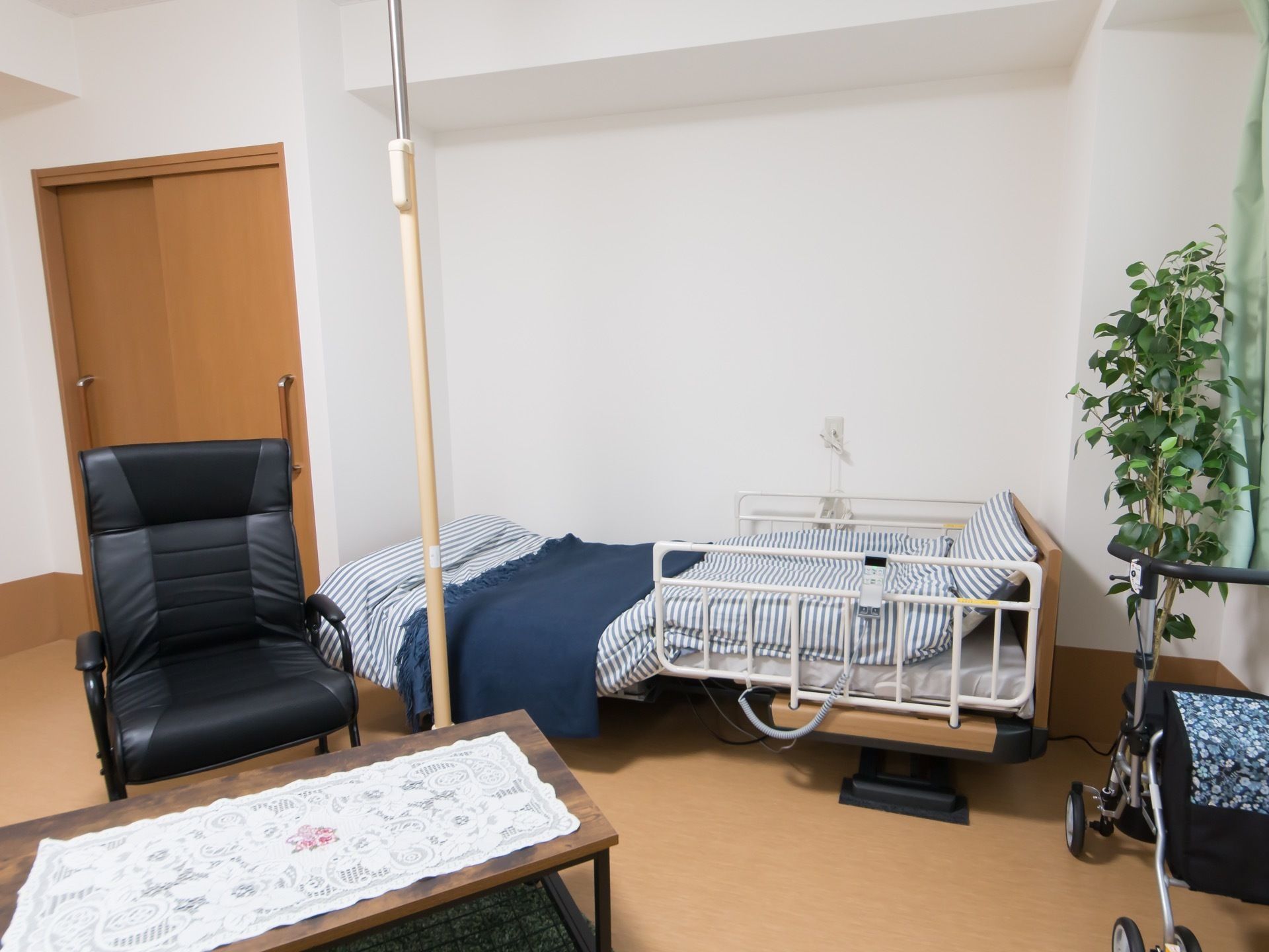 居室は白い内装で、明るく清潔感がある。介護用ベッドを配置し、部屋の中央をより広く利用できるようにしている。