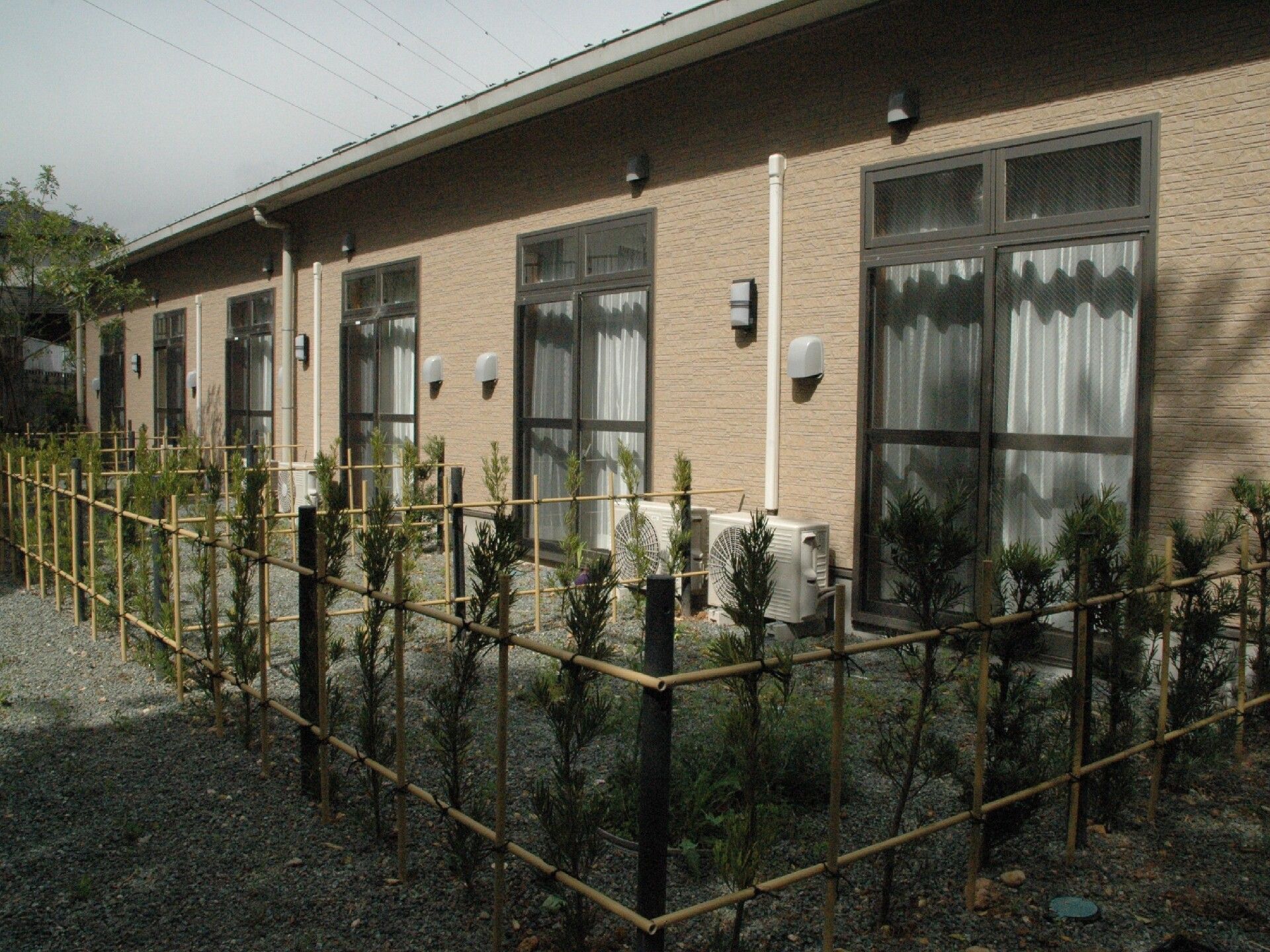 中庭に通じる部屋がある建物。整備された庭と建物の近影写真