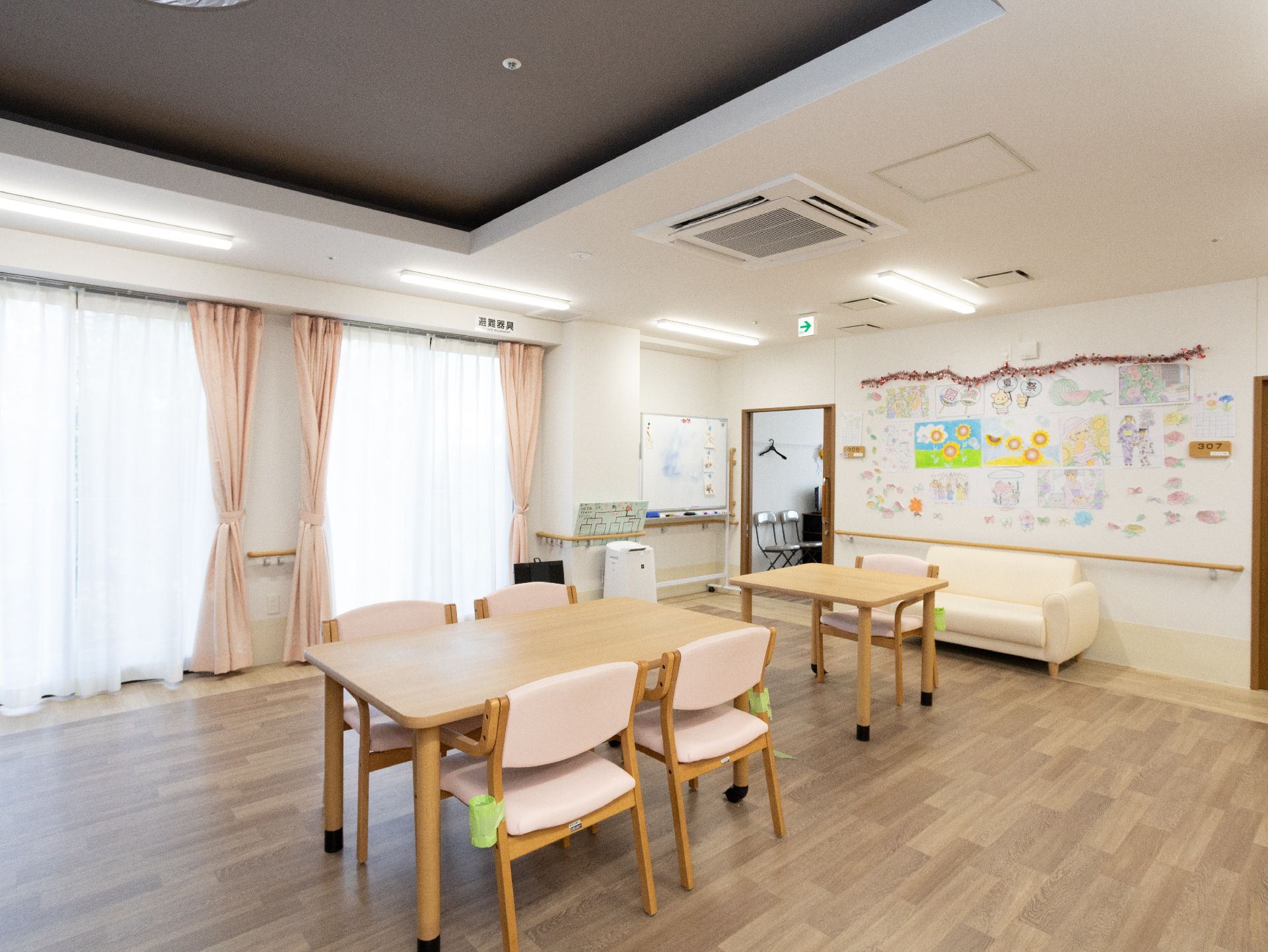 窓から光がたっぷりと入り、壁に展示物がたくさん貼られているリビング