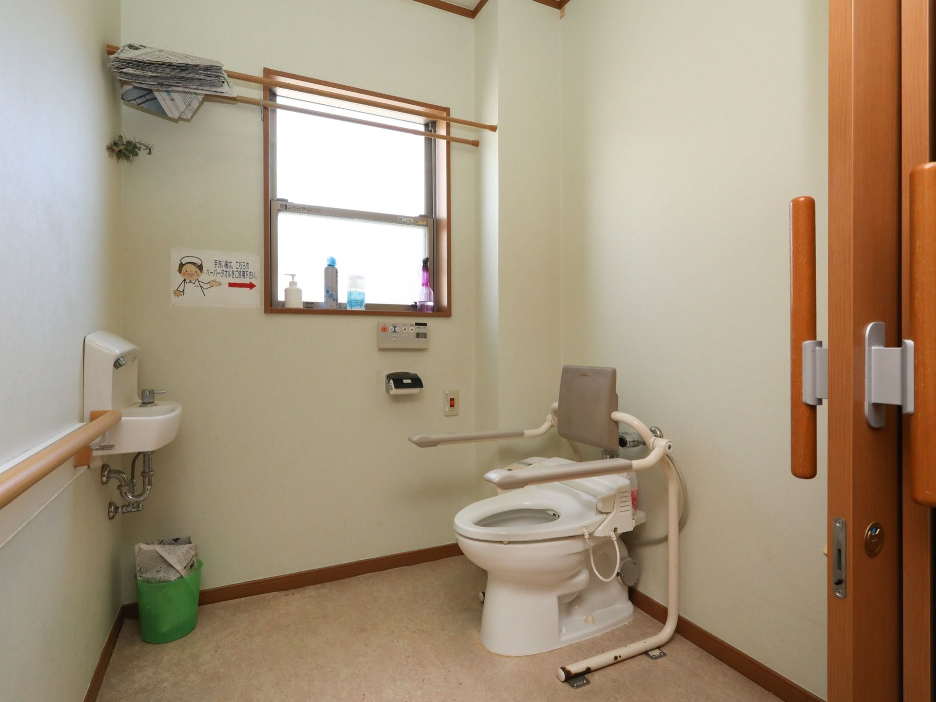 広くスペースが確保されたトイレには換気窓が設置され、背もたれパッド付きの手すりが装備された温水洗浄便座が完備されている。