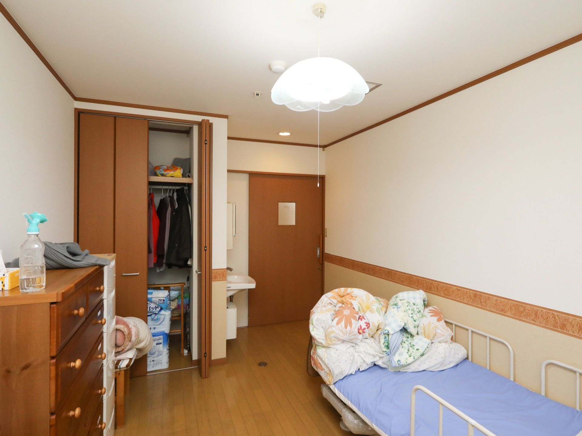 居室には、壁際に介護用ベッドが設置されている。収納クローゼットが完備され、手洗い場が設けられている。