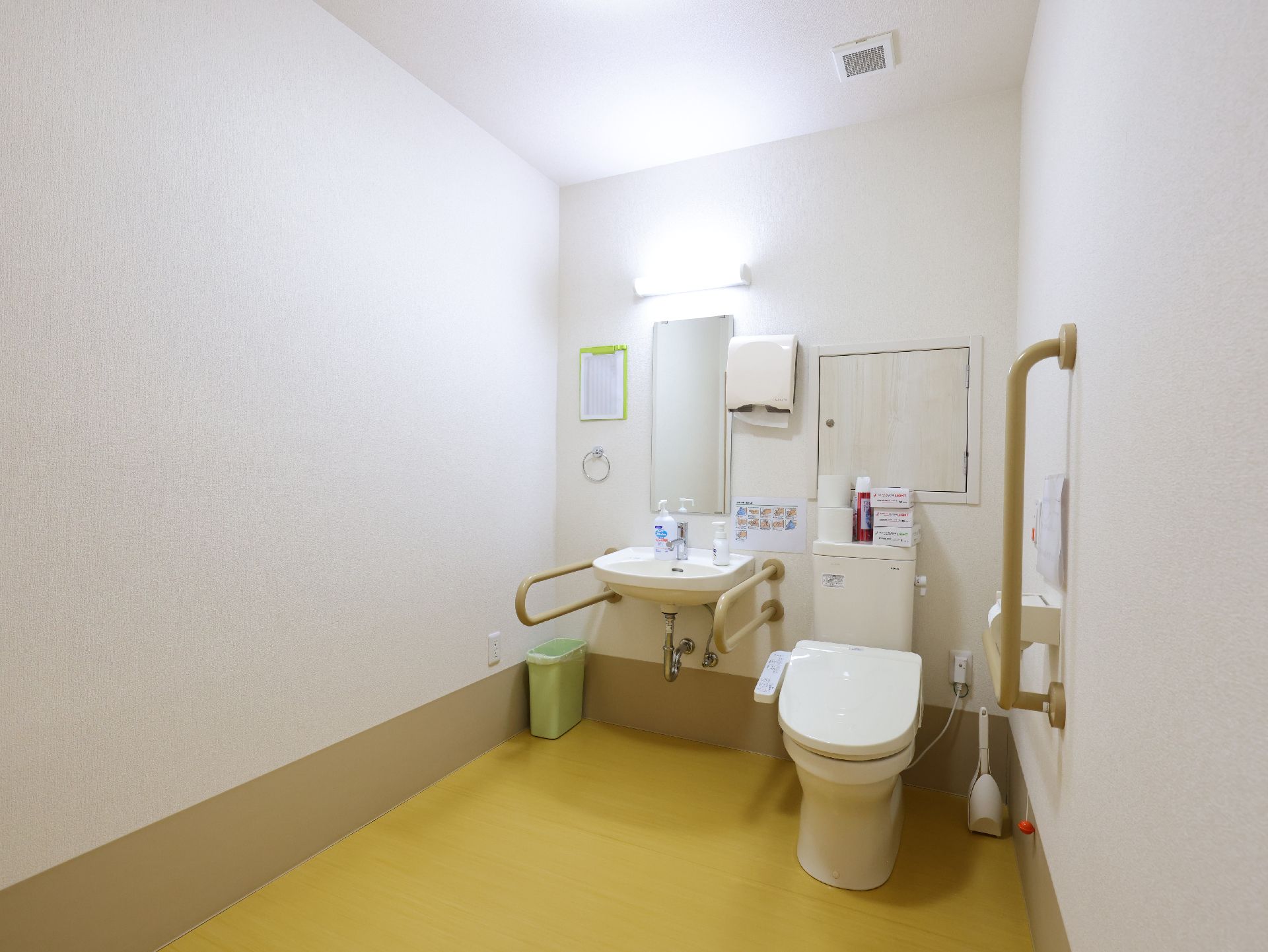 白いトイレに独立洗面台の設置されたトイレ