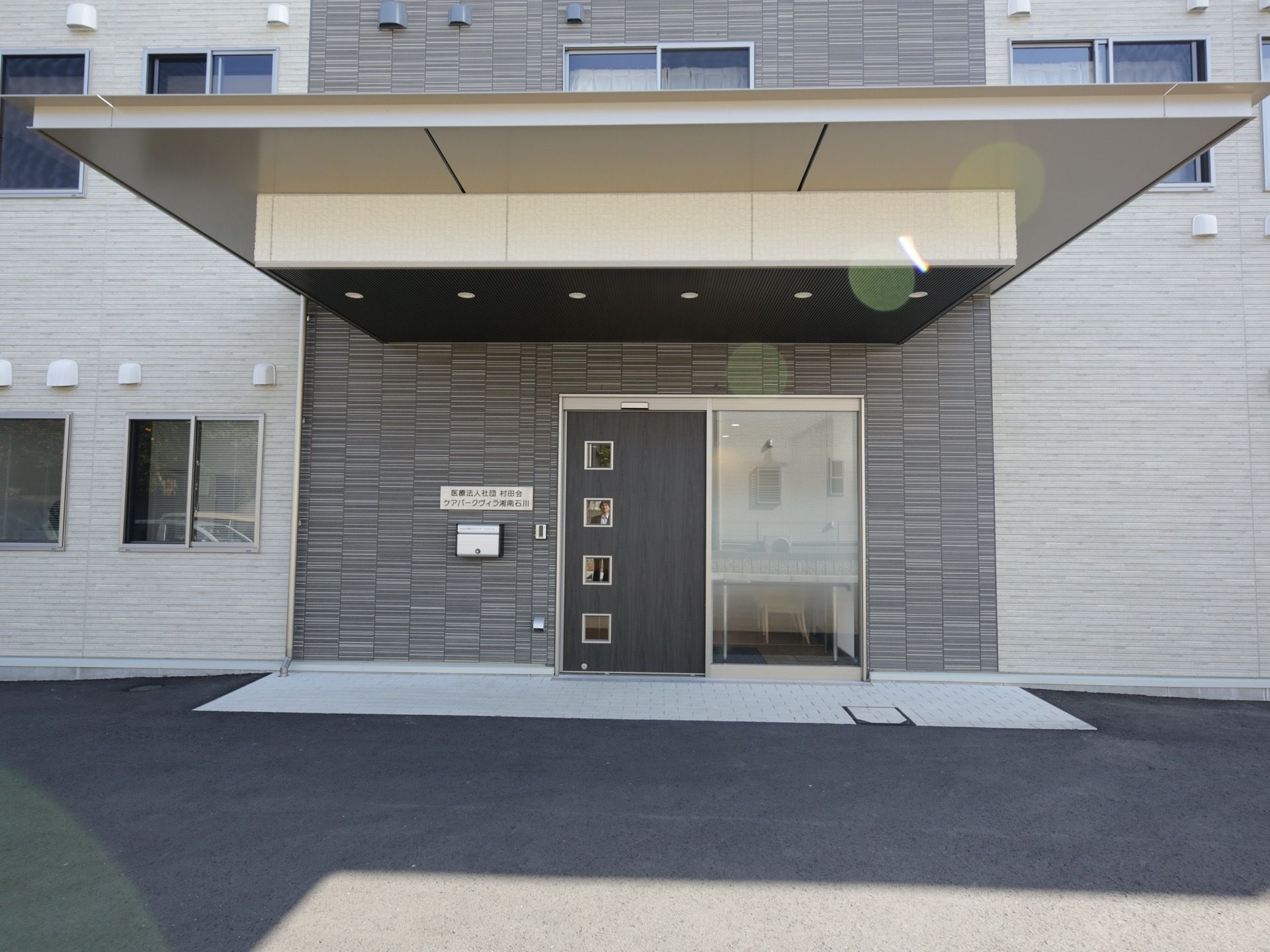 駐車場から建物へのアプローチに段差がない。正面入口の車寄せの上まで覆う大きなひさしがあり、悪天候の日もストレスなく出入りできる。