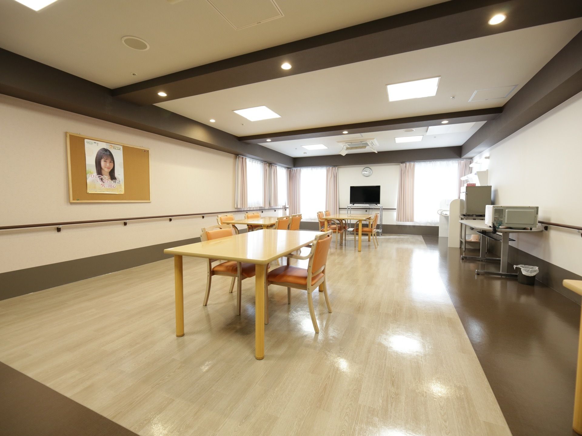 食堂は、ベージュと茶色の内装で落ち着いた印象である。テレビや、掲示用のボードが設置されている。ダイニングテーブルの配置にゆとりがある。