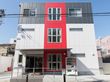 青と白と赤で塗装された３回建ての建物である。入り口まではスロープになっていて、手すりも取り付けられている。