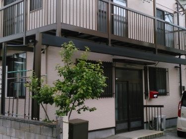 なにかを指さして笑顔で話している車いすの女性とそれを押している介護スタッフの様子