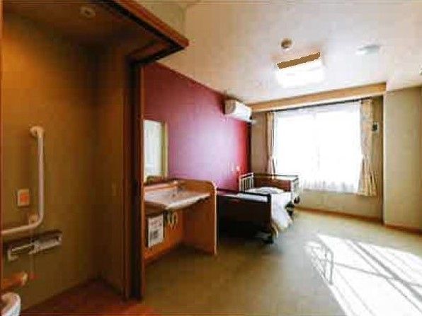 広い居室には介護用ベッドや洗面所、トイレが付き、エアコンも設置されている。
