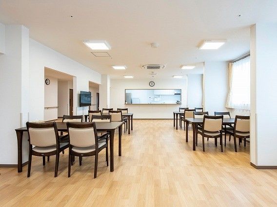 ４人掛けのダイニングテーブルが並べられた食堂には壁掛けテレビや対面式キッチンもある。