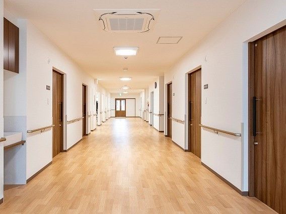両サイドに手すりが付いた幅の広い廊下。突き当りにはドアがあり、明るい雰囲気。