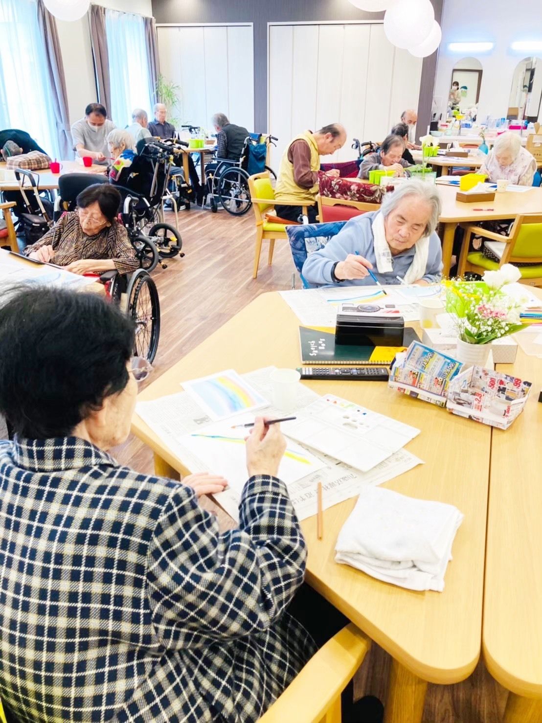 リビングスペースでスタッフや利用者同士で交流している様子。日中の施設内