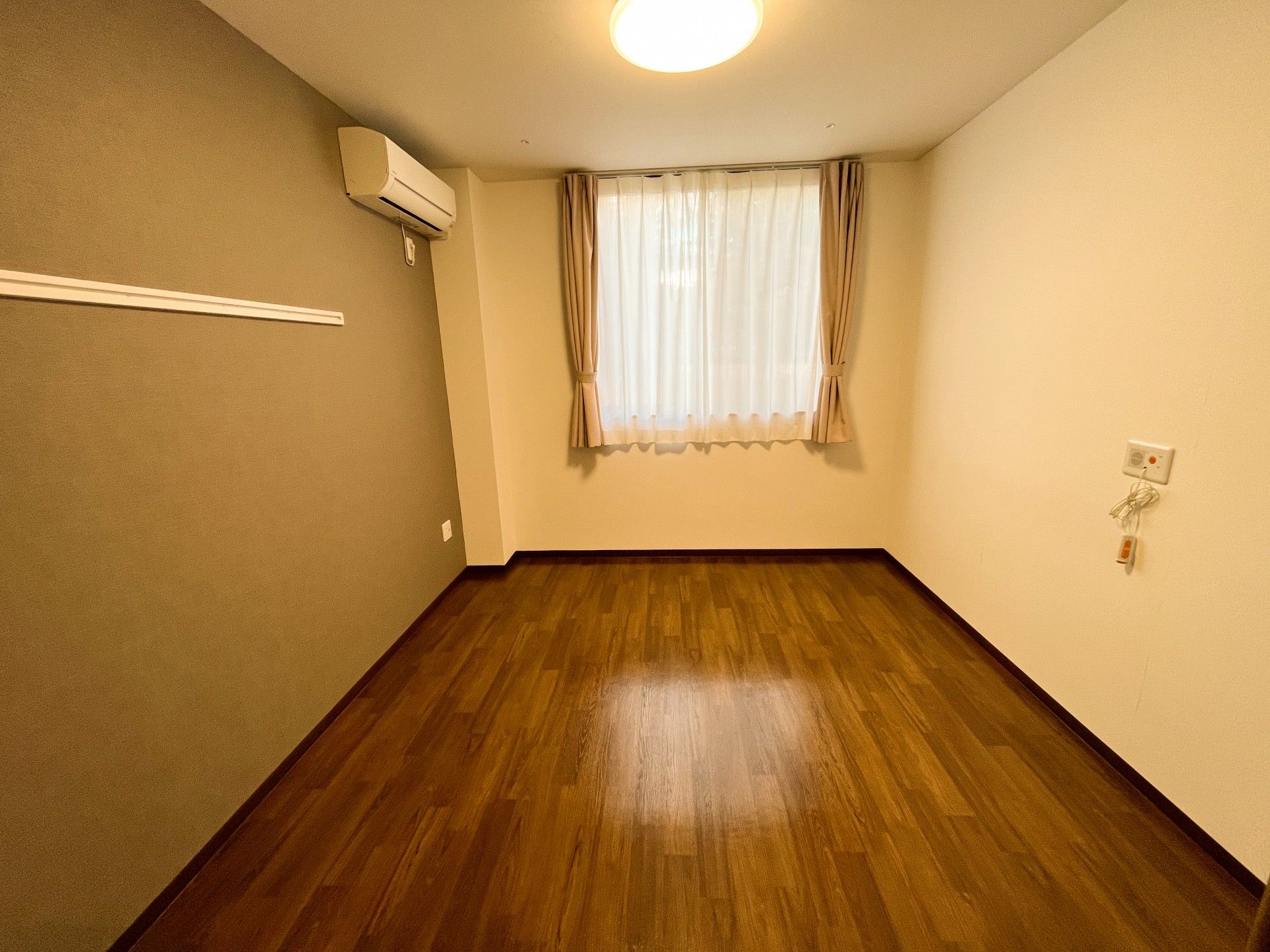 眼鏡をかけた車いすの男性入居者と女性スタッフが屋外での散歩を楽しんでいる。